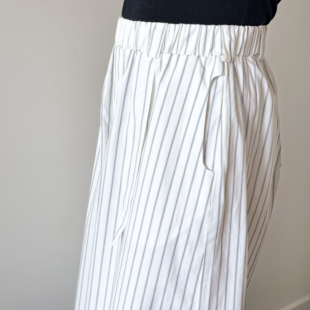 White pants with thin black stripes on a plain background