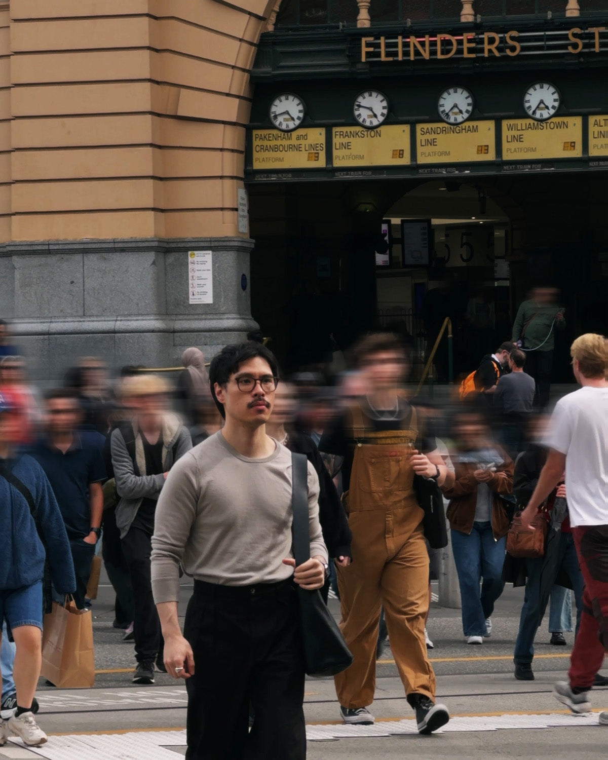 Man wearing Studio Luho Work Trouser in black walking at Flinders Street Station Melbourne