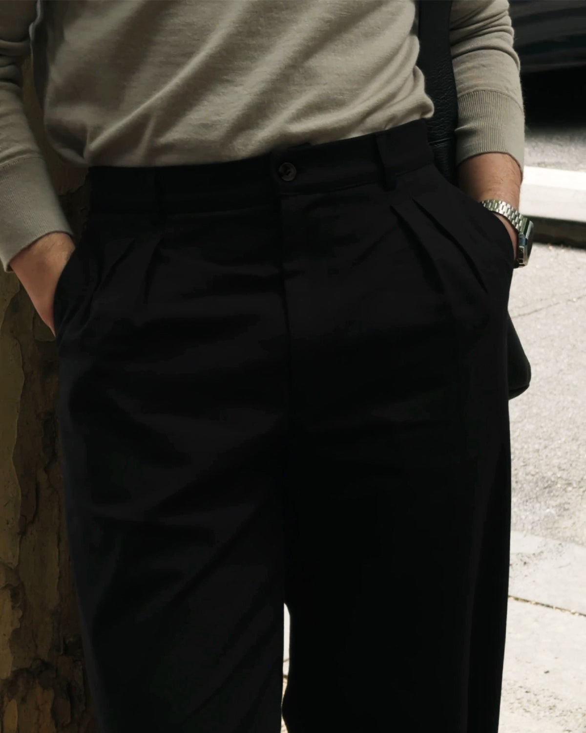 Close-up detail of Studio Luho Work Trouser in black showing twin front pleats and high-rise waistband