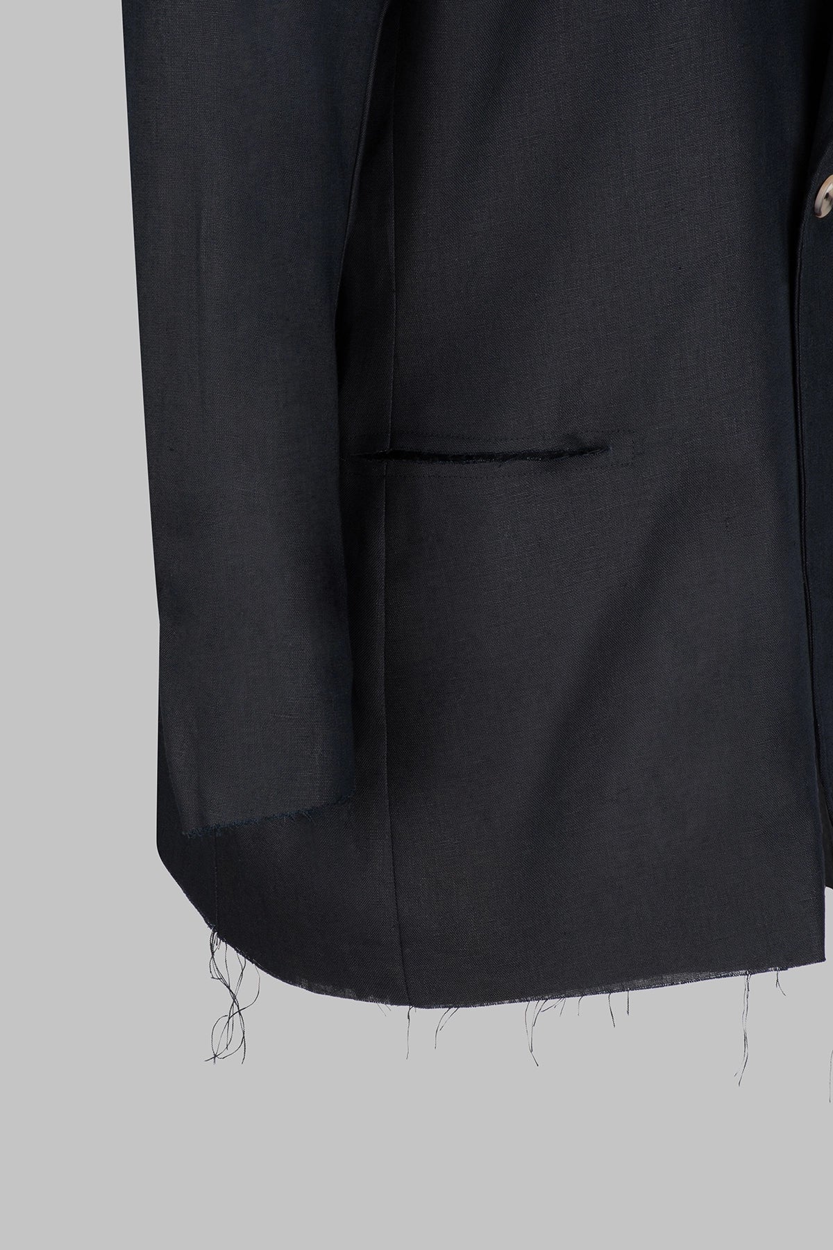 Closeup view of the Studio Luho deconstructed European linen blazer in black.