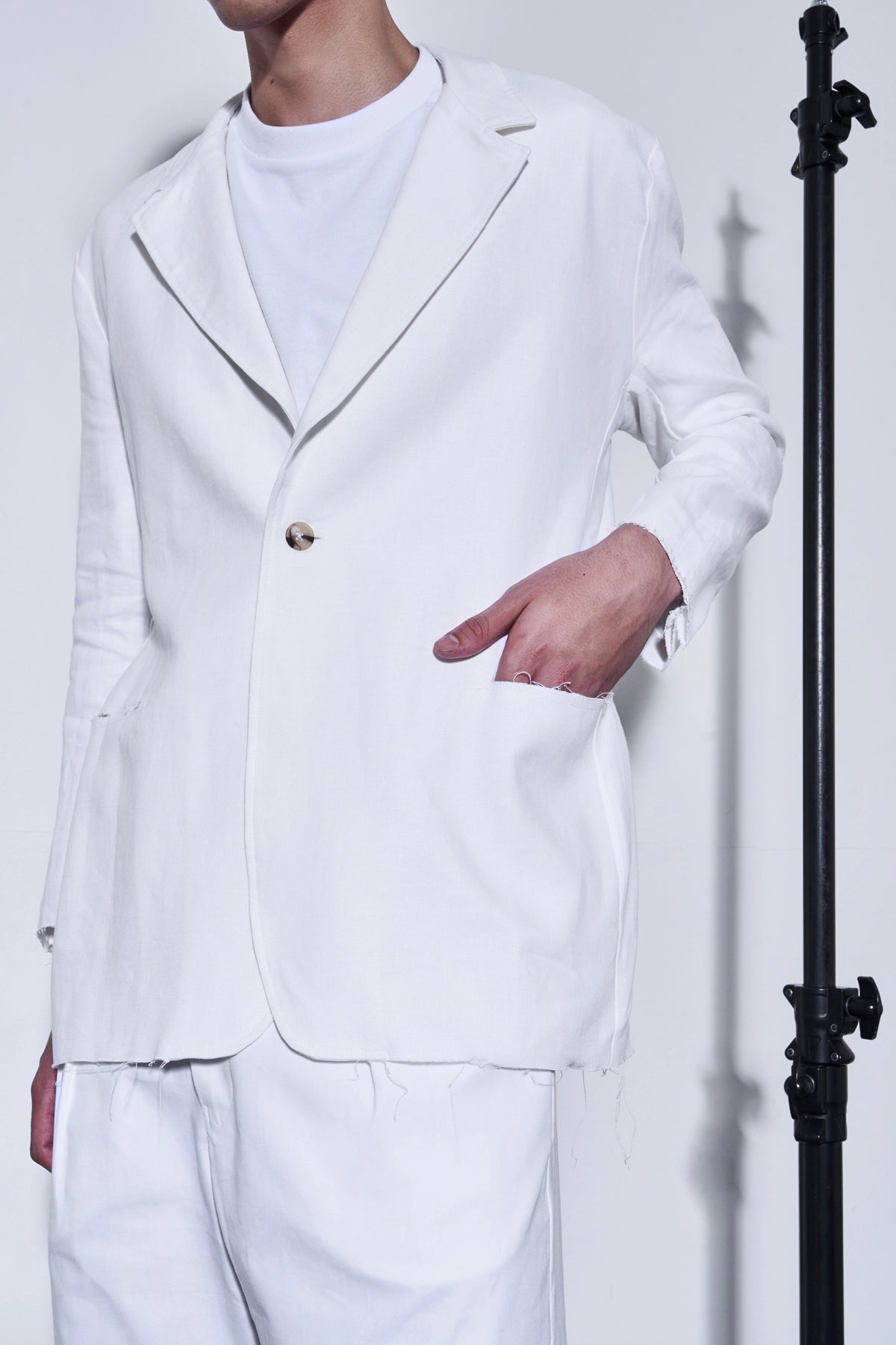 Person wearing a white suit against a plain background