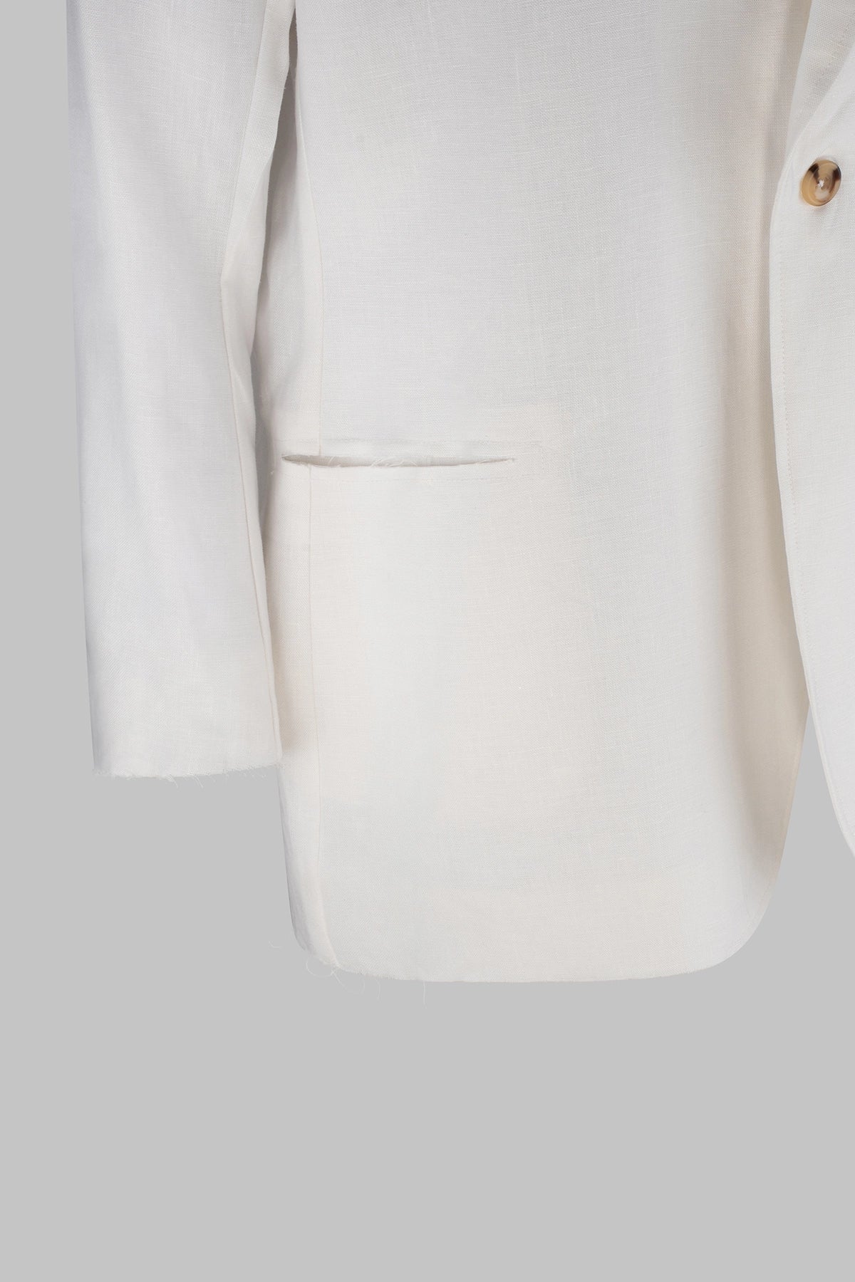 Close-up of a white suit jacket on a light gray background