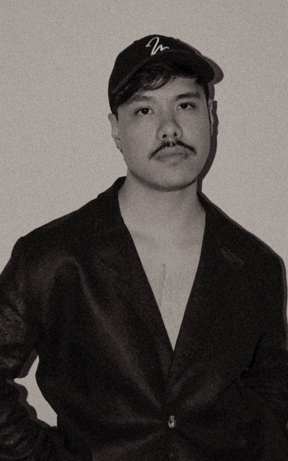 Studio Luho Founder Javier wearing the black linen blazer and signature trucker cap