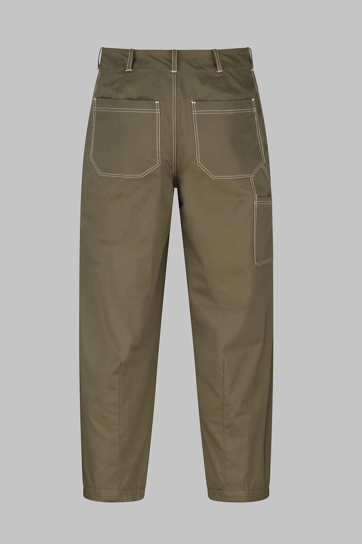 A pair of olive green fatigue trousers shown from the back, featuring white contrast stitching and multiple utility pockets, set against a solid gray background.