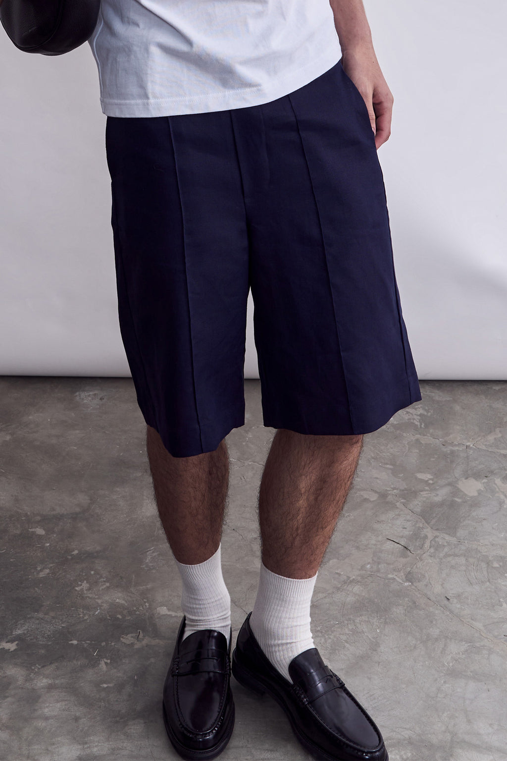 Model wearing the relaxed fit navy linen shorts from Studio Luho.