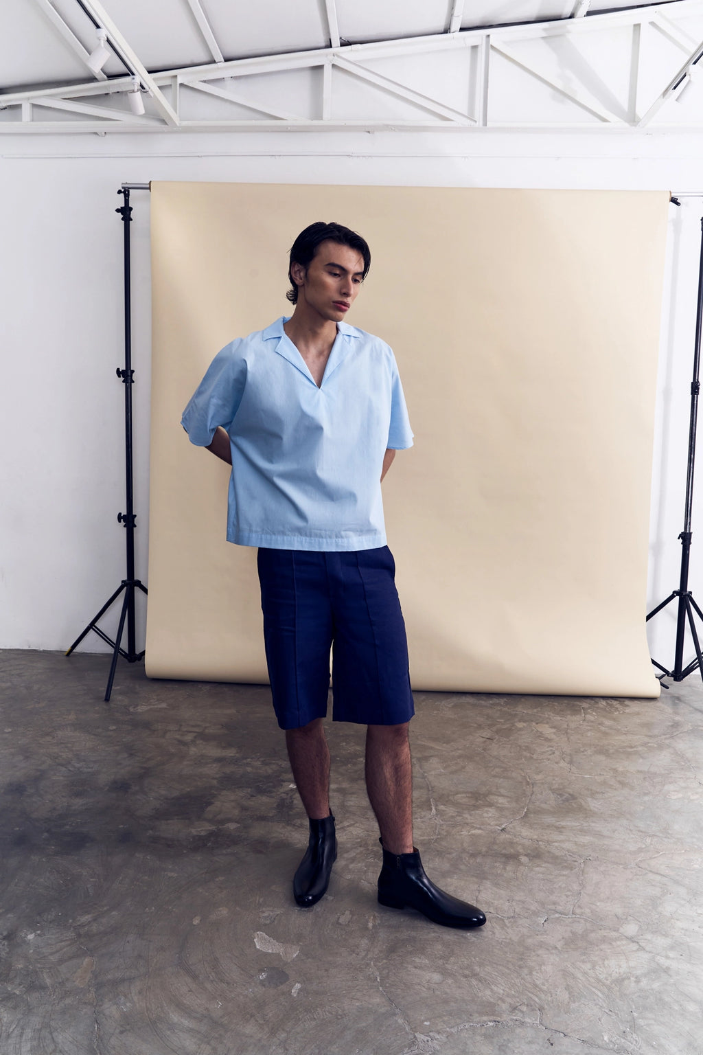 Model wearing the light blue short sleeve poplin shirt from Studio Luho.