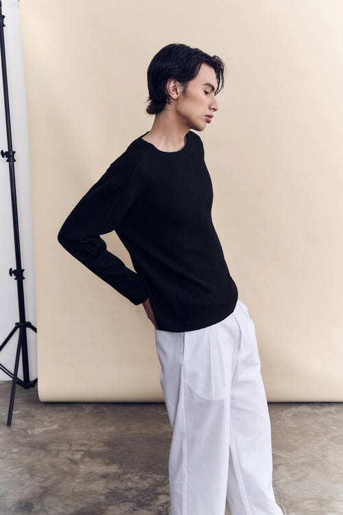 Model wearing the black waffle knit long sleeve as a layering piece by Studio Luho.