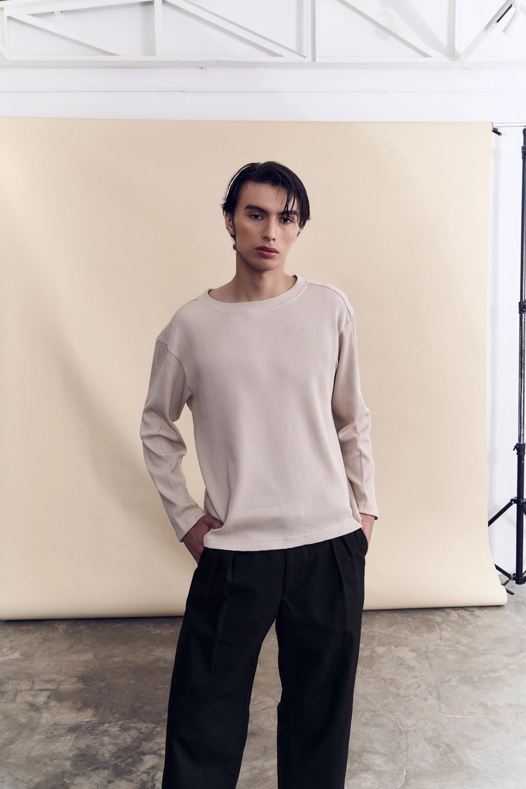 Model wearing the sand waffle knit long sleeve as a layering piece by Studio Luho.